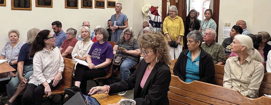 A portion of the crowd that showed up at the special meeting on Friday, Aug. 28 because of an agenda item to “discuss and possibly approve a disaster declaration concerning illegal immigration, human trafficking, and drug smuggling.” County Emergency Management Coordinator and Grants Specialist Angela Hahn (back, center) is shown speaking on the topic. Photo By Melanie Berger / Courtesy of Flatonia Argus