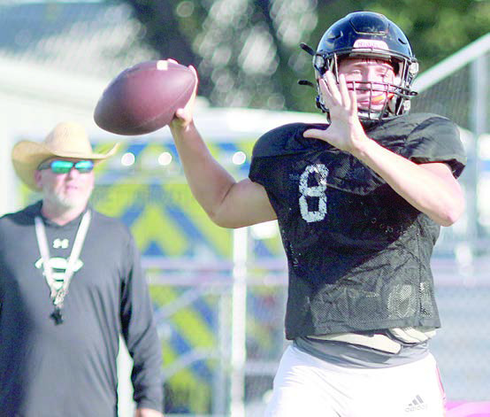 Returning senior quarterback Owen Brenek delivers a pass in the Shorthorns’ first scrimmage last Thursday as head coach Clay Ferguson looks on. Sticker Photo By Darrell Vyvjala