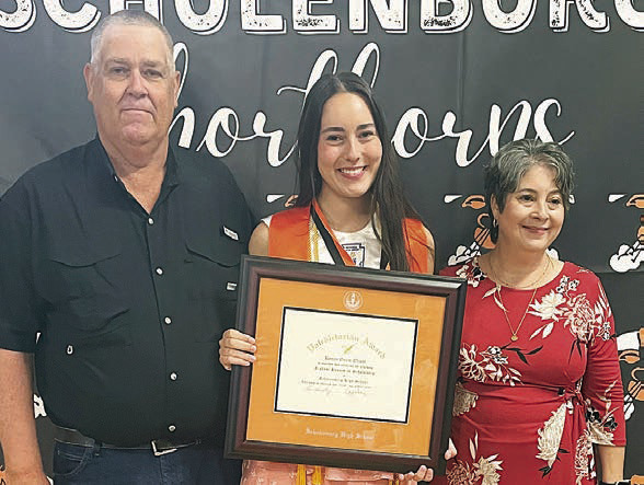 Kenna Oliver (center) receives the valedictorian plaque and medal with her parents, Wesley and Carrie Oliver, alongside at the Senior Scholarship Banquet. Sticker Photo By Darrell Vyvjala