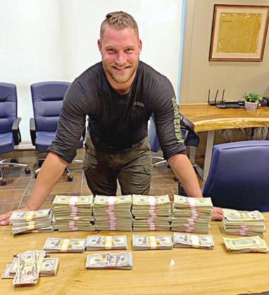 Reserve Drug Interdiction Investigator Jeremy Ellison with the $186,070 in U.S. currency confiscated as part of a money laundering arrest made during a traffic stop on I-10 near Flatonia.