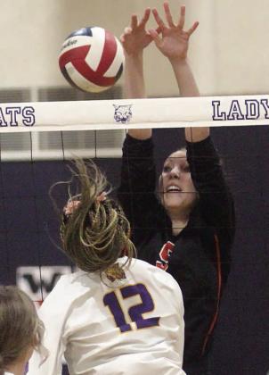 Brooke Redding deflects a Ladycat attack in the first set. Sticker Photo By Darrell Vyvjala
