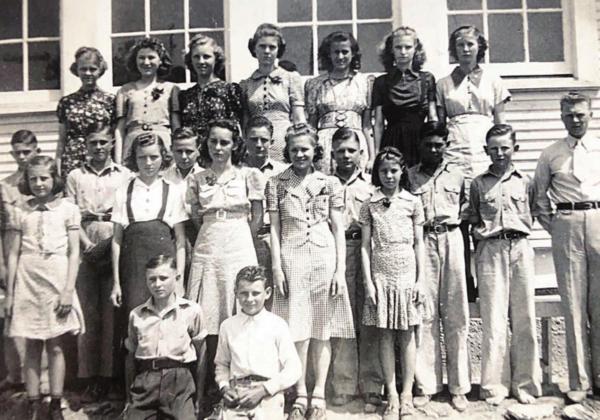 Standing directly behind the kneeling boys, Florence poses with her classmates and their teacher, Otto Banik, in 1941. Few students went beyond the ninth grade because they lacked transportation to attend Schulenburg High School.