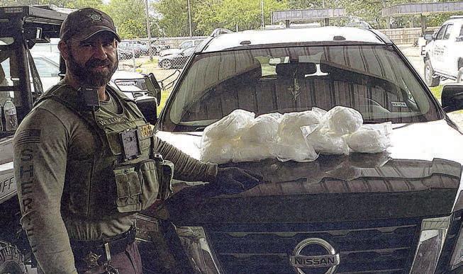 Deputy Cody Williams is shown with the nine bundles believed to contain methamphetamine that were seized following a traffic stop on the Nissan SUV. Photo Courtesy of Fayette County Sheriff’s Department