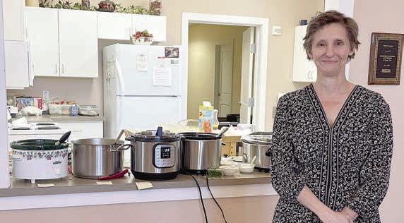 Guest sp eak er was Dawn Orsak, who is authoring a book of Texas Czech foods. She stands in front of pots of soups served at the social.