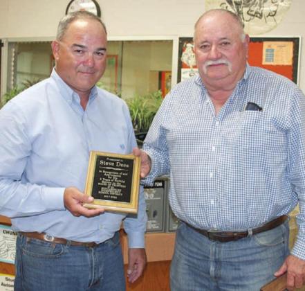 Schulenburg ISD Board of Trustees President Craig Schulz (left) presents outgoing trustee Steve Dees a plaque at Monday night’s meeting in appreciation of his service to the district over the past five years. In addition, Tony Shank (not present) was recognized for serving as a trustee for the last three years. Sticker Photo By Darrell Vyvjala