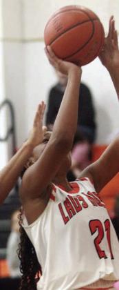 Jashiya Jackson scores under the basket in the second half of the Lady Horns’ home game on Dec. 20. Sticker Photo By Darrell Vyvjala