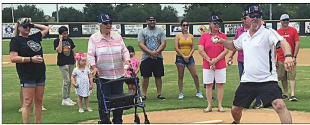 Danny Neiser (right) throws out the first pitch in honor of his late father, Daniel, prior to the Vets’ game Sunday. Family members joining in the ceremony were (at the mound, from left) Ann Dobecka, Janie Neiser, Linda Besetzny, and (behind Danny) Lori Leer. Other family members are shown in the background.