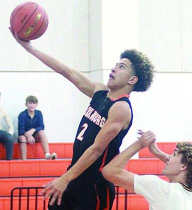 Denver Carr goes up for a layup in the first half against Sealy last Friday. Sticker Photo By Darrell Vyvjala