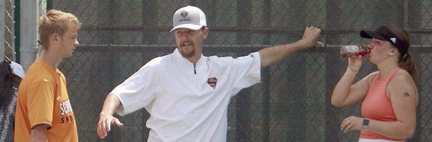 SHS tennis coach Jordan Hafley (center) talks to his doubles team during a change-over between games at state. Sticker Photo By Darrell Vyvjala