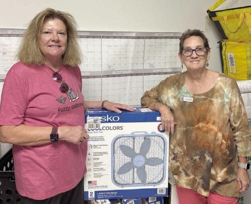 Thanks go to Nancy Hoelscher Parrish (pictured) and Denise Hoelscher Koenig (not shown) for their recent donations to Senior Connections. In the photo at left, Parrish is pictured with donated bingo prizes. In the photo at right, Parrish and Senior Connections program director Stephanie Shroyer (right) stand beside one of six fans they donated for the fan drive on Thursday, Aug. 28.