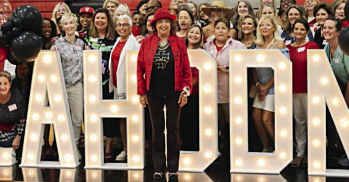 Jan Lahodny is shown in front of a lighted sign bearing her name during a dedication ceremony at Victoria High School gym last year, when the court was named in her honor.