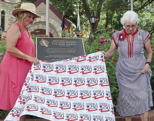 Daughters of the American Revolution Smith McMillan Chapter Regent Gina Minzenmeyer (left) and Past Regent Carolyn Caflisch (right) unveil the patriot marker for John Sorrell at the Veterans Memorial section on the Courthouse square.