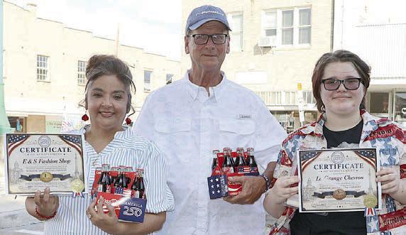 Announced as the top three winners of the Window Decorating Contest were: 1st Place – E&amp;amp;S Fashion Shop of Schulenburg, represented by Esther Toro (left); 2nd Place – Round Top Real Estate; and 3rd Place – La Grange Chevron, represented by Calvin Mersiovsky (center) and his granddaughter, Scarlett Landry (right).