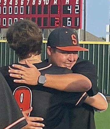 With the final score posted on the scoreboard, head coach Marty Bigham hugs Jayse Janda, one of his five seniors. Sticker Photo By Darrell Vyvjala