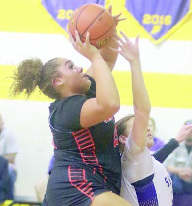 Arianna Vincent goes up over a Lady Comanche to score in the first quarter. Sticker Photo By Darrell Vyvjala