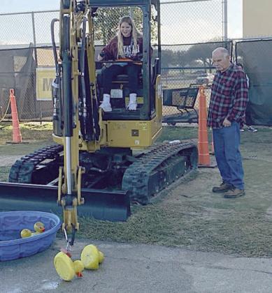 Picking up giant ribber ducks is Brynlee Berger while her grandfather Arlan Berger “supervises.”