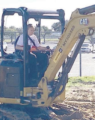 Operating an excavator are Zoey Krenek (left) and Penny Bartek (right).