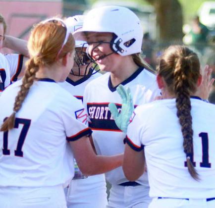 Teammates congratulate Aubryn Janda at home plate after her home run last Tuesday. Sticker Photo By Darrell Vyvjala