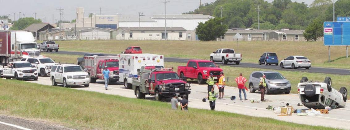 First responders work the accident on Interstate 10 eastbound just east of the Schulenburg exit near midday this past Sunday, when an overturned SUV snarled traffic for some 40 minutes. Sticker Photo By Darrell Vyvjala