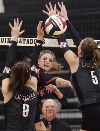 Emmrie Marx fires a kill in between two Johnson City blockers in the second set. Sticker Photo By Darrell Vyvjala