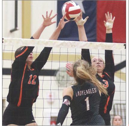 Grace Schramek (No. 12) and Reagan Dusek go up to get a piece of a Lady Eagle attack in the second set. Sticker Photo By Darrell Vyvjala