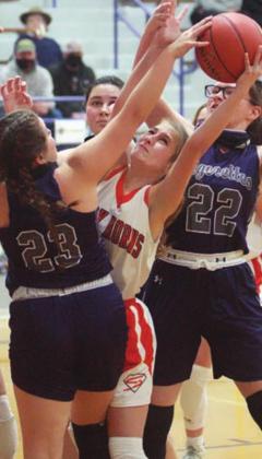 Megan Ohnheiser battles a pair of Tigerettes for a loose ball in the fourth quarter. Sticker Photo By Darrell Vyvjala