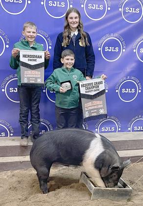 RESERVE CHAMPION MARKET SWINE – Exhibitor: Madyson Holub (back, right). Sales price: No sale. Sticker Photo By Darrell Vyvjala