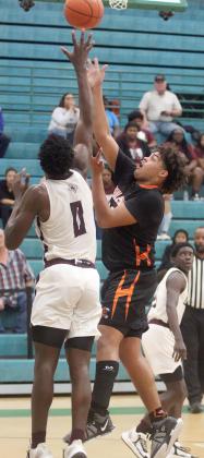 Jayvan Luhrs hits a shot in the lane over Dereion Mitchell in the fourth quarter. Sticker Photo By Darrell Vyvjala