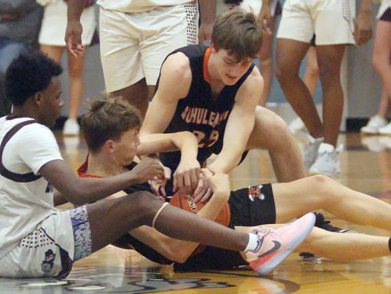 Van Prihoda wrestles the ball away from a Bulldog in the second half with a little help from Zane Brenek. Sticker Photo By Darrell Vyvjala