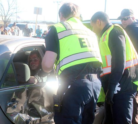 EMS personnel check on an injured teen trapped inside one of the vehicles. Sticker Photo By Darrell Vyvjala