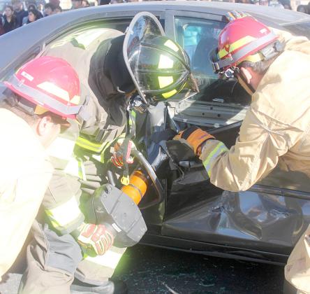 Firefighter work to extricate one of the accident victims. Sticker Photo By Darrell Vyvjala