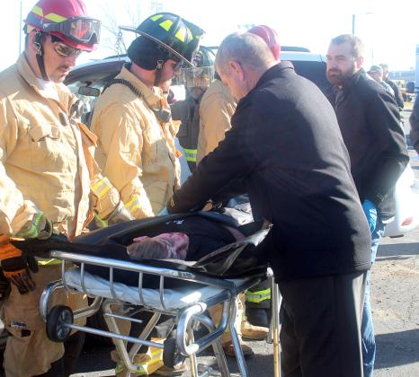 Bryan and Clayton Klesel (right) of Schwenke-Baumgarten Funeral Home, with the help of SVFD personnel, place the “deceased” body of Jamison Bennett in a body bag for transport to the funeral home. Sticker Photo By Darrell Vyvjala