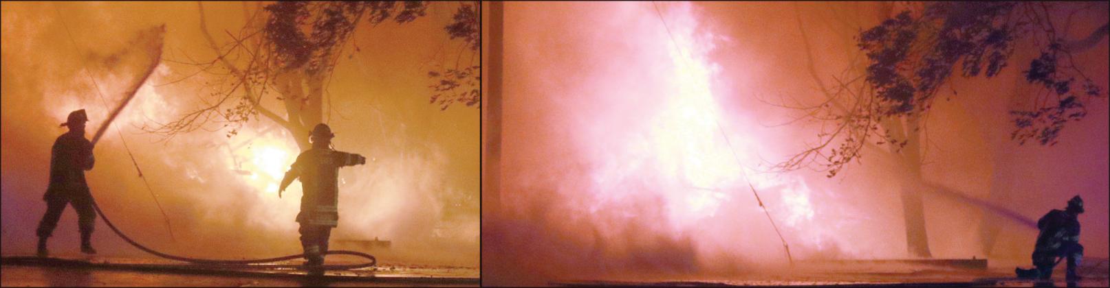 Firefighters work to knock down the flames on the south side of the blaze from Summit Street