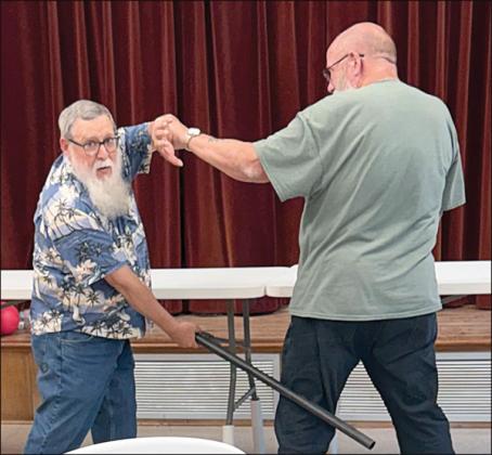 deMONSTRATiNg SeLF-deFeNSe TeCHNiqUeS to members in  Weimar was David MaCall (left). This was just a taste of the program he will  put on in the near future. David Wyman (right) was kind enough to help with the demonstration.