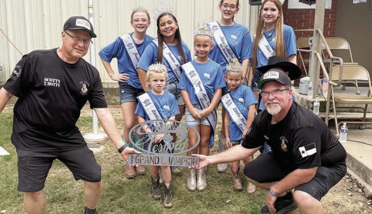 GRAND CHAMPION / 1ST PLACE CHICKEN – “Wild Thang Cookers” of Cameron, represented by Steve Siebeneicher and Scott Lusk. Also shown is Miss Schulenburg and her court. Sticker Photo By Layne Vyvjala