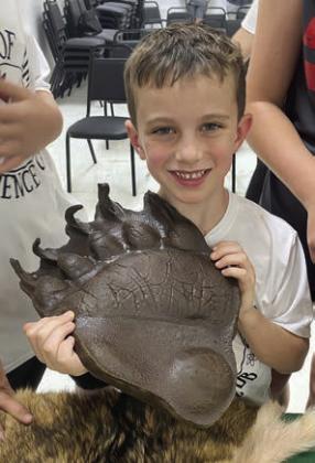 Holding a grizzly bear track is Cason Hale.