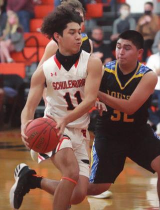 Manny Herrera drives past a Hornet for a bucket in the second quarter. Sticker Photo By Darrell Vyvjala