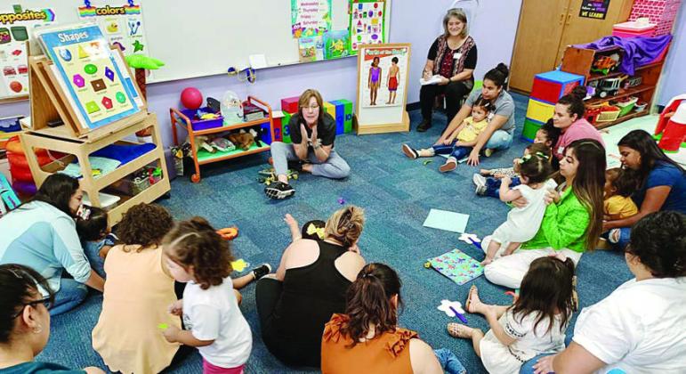 Juanita Duchicela (seated at back center) leads a session in the Learn &amp;amp; Play Room. Duchicela is retiring from the Parents As Teachers program after 20 years of service.