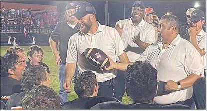 Defensive coordinator Isaiah Barrera (right) presents the game ball to head coach Luke Hobbs. Sticker Photo By Darrell Vyvjala