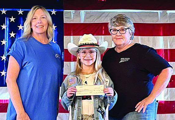 Marley Vasek (center) presents a donation to Lucies Project in Sheridan, represented by Julie Candela (left); and Liberty For All Service Dogs in Kempner. Also shown is Wendee Galleymore (right), Holman Valley Steakhouse owner.