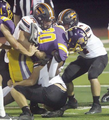 Marshall Wellborn (No 70), Aidan Mendez (right), and John Davis (below) wrestle down Dereon Johnson after a short gain in the first quarter. Sticker Photo By Layne Vyvjala