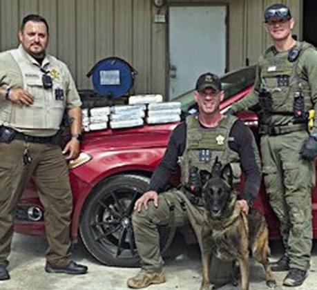 From left: Deputy Herman Olvera, Drug Interdiction Sgt. Randy Thumann and K-9 Kolt, and Drug Interdiction Investigator David Smith are shown with the 11 kilos of cocaine they seized on May 16.