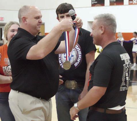 Head coach Donald Zapalac presents Gary Pauler with a state semifinalist medal, making him an honorary member of the team for his long-time support in cheering on the Lady Horns.