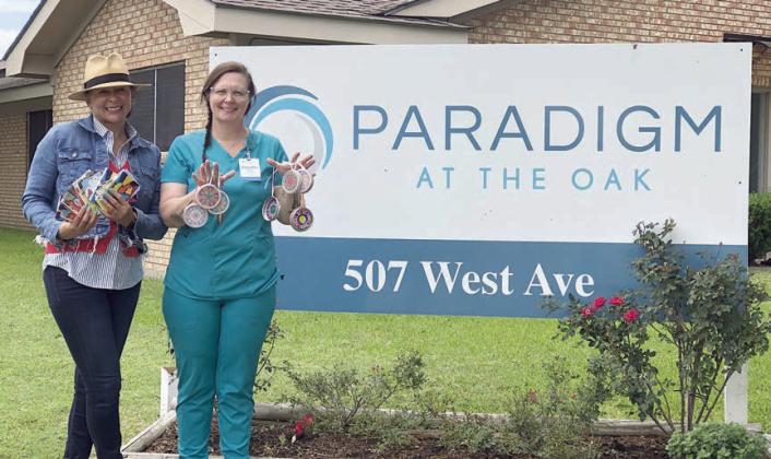 Sun-catchers and greeting ca rds were given to Paradigm at the Oak by Senior Connections, with Pam Noell (left), Paradigm director, and Jennifer Wilson (right), Paradigm activity director, displaying some of the items.