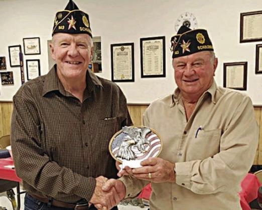 Post 143 Commander Bob Heinrich (right) presents the 2023 Legionnaire of the Year Award to C. W. Leonard.
