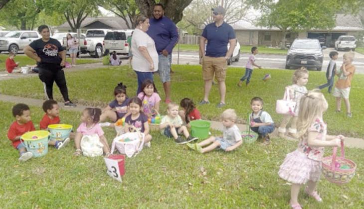 Some of the children sit with their buckets and baskets filled with the Easter eggs that they’ve found while others continue to search for more eggs that were placed around the grounds at the First Methodist Church.