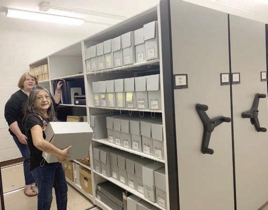 Organizing the new shelv ing at the Fayette Heritage Museum &amp;amp; Archives in La Grange are archivists Maria Rocha (front) and Rox Ann Johnson.