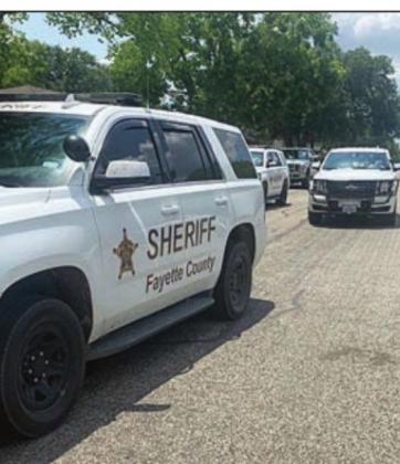 Law enforcement officers converge on a residence on Baumgarten Street Friday to execute a search warrant.