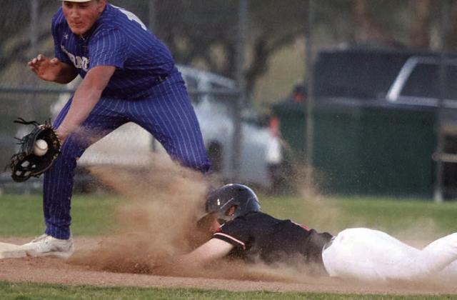 Reid Janda beats a Hornet tag with a head-first slide into third base for a steal in the bottom of the first inning. Sticker Photo By Darrell Vyvjala