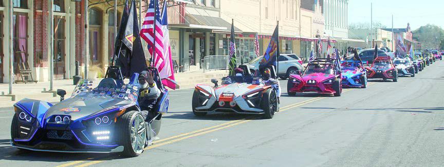 Colorful Slingshot three-wheel vehicles, totaling 65, with drivers from San Antonio, Houston, and La Grange highlighted the parade through downtown. Sticker Photo By Darrell Vyvjala